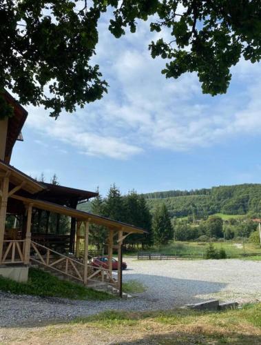 a pavilion with a car parked in a field at La Lacuri in Sovata