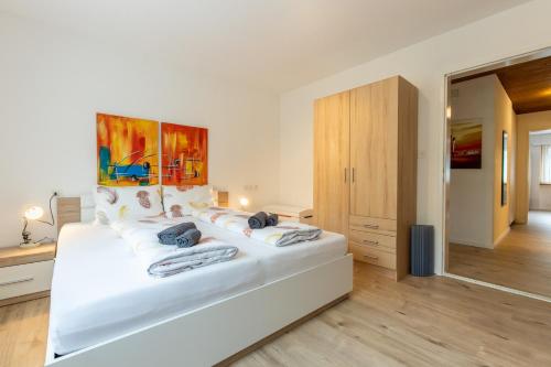 a white bedroom with a large white bed with pillows at Chasa Vista Lischana in Scuol
