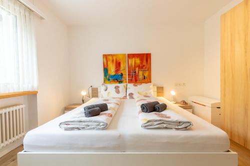 Un dormitorio con una cama blanca con toallas. en Chasa Vista Lischana, en Scuol