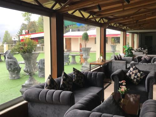 a living room with couches and a large window at BULAND HEIGHTS in Murree