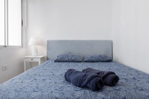 ein Bett mit einer blauen Decke darüber in der Unterkunft Casa Maravillosa - Seaview in Los Llanos de Aridane