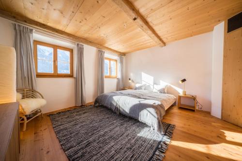 1 dormitorio con cama y alfombra en Chasa Pro la Tuor, en Ardez