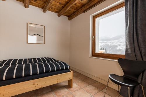 TaraspにあるChasa La Tschuffaのベッドルーム(ベッド1台、窓付)