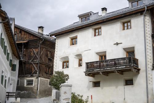 a white building with a balcony on the side of it at Chasa Riatsch in Ardez