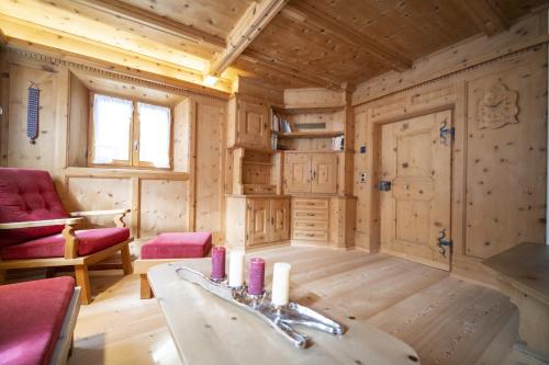 a log cabin living room with a table and chairs at Chasa Riatsch in Ardez