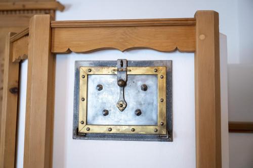 a clock on a wall with a wooden frame at Chasa Riatsch in Ardez