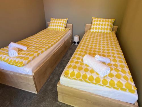 - 2 lits dans une chambre avec des draps jaunes et blancs dans l'établissement Pokoje u Daniela, à Międzygórze