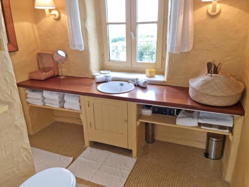 a bathroom with a sink and a window at 544-Villa Kernod Face a la mer in Esquibien