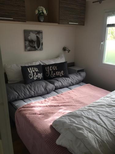 a bed in a bedroom with two pillows on it at Chalet Strandliebe Bredene in Bredene