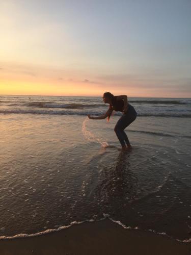 a woman is playing in the water on the beach at Chalet Strandliebe Bredene in Bredene