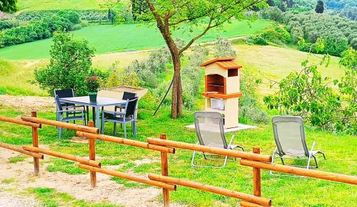 a wooden fence with chairs and a table and a bird house at La Giara, san Miniato in Sorrezzana