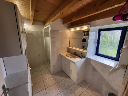 une petite salle de bain avec un lavabo et une fenêtre dans l'établissement 375- Villa Ker Goulien a 100m de la plage, à Crozon