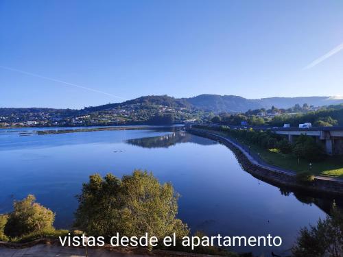 arial view of a river with a city at O Paseo, 5 estrellas. in Puentedeume