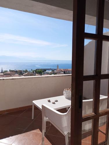 a balcony with a table and a view of the ocean at Scario house in Scario
