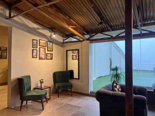 a living room with a couch and two chairs at BULAND HEIGHTS in Murree