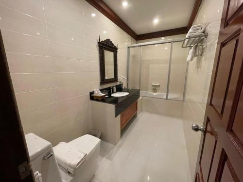 a bathroom with a toilet and a sink and a mirror at Athena Hotel in Pakse