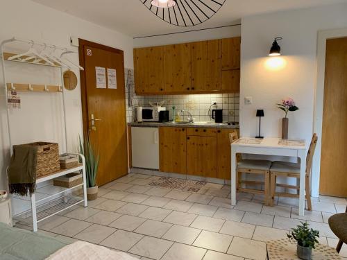 a kitchen with wooden cabinets and a table at Le Tortin - studio centré et calme - 2 personnes in Nendaz