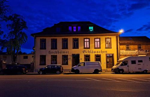 um edifício com dois carros estacionados em frente em Pension Hochheimer Schlösschen em Erfurt