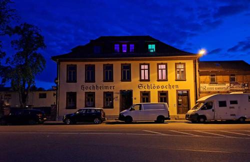 ein Gebäude mit zwei davor geparkt in der Unterkunft Pension Hochheimer Schlösschen in Erfurt