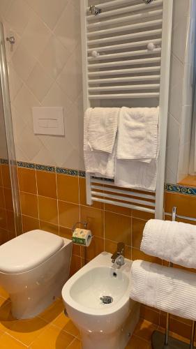 a bathroom with a sink and a toilet and towels at villa verde sul mare in Vietri sul Mare