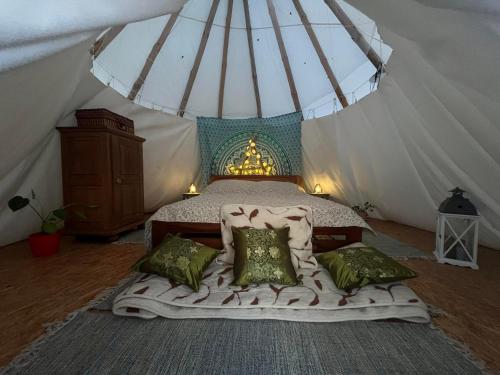 ein Schlafzimmer mit einem Bett in einem Zelt in der Unterkunft Malowane Wrota in Łazy