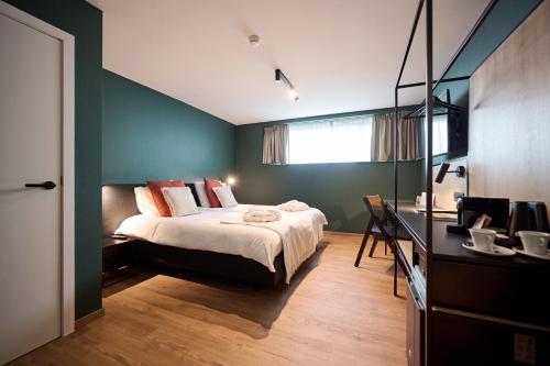 um quarto com uma cama e uma secretária com uma televisão em Hotel La Malle Poste em Rochefort