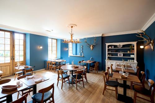 a dining room with blue walls and tables and chairs at Hotel La Malle Poste in Rochefort