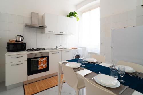 - une cuisine avec une table, des chaises et une cuisinière dans l'établissement Luminoso appartamento vicino alle Cinque Terre (CITRA: 011015-LT-3028), à La Spezia