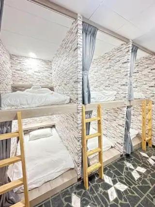 Economy Class Hostel في دايوان: غرفة بسريرين بطابقين وسلم