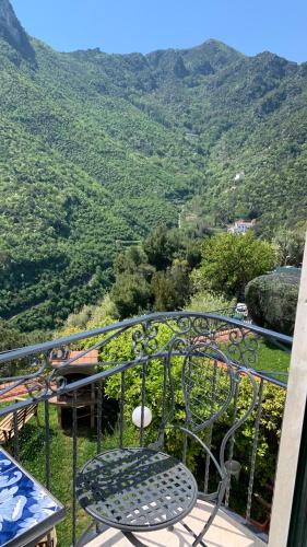 a chair and table on a balcony with a view of a mountain at villa verde sul mare in Vietri sul Mare