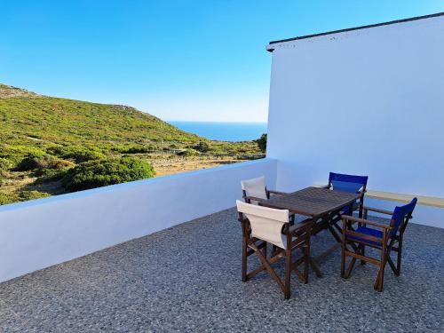 a table and chairs on a balcony with a view of the ocean at Sophie's Pourko House in Kýthira