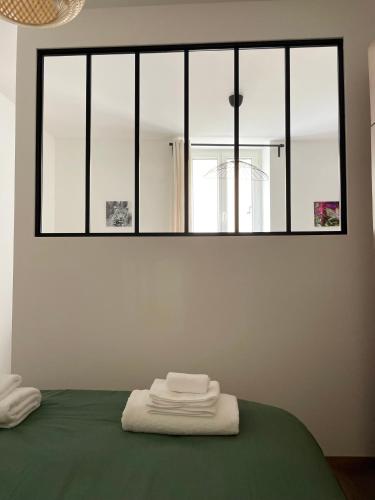 a bed with two towels sitting on top of it at La maison douce in Lons-le-Saunier
