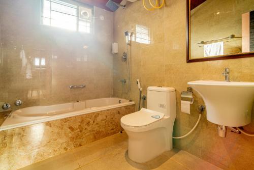 a bathroom with a toilet and a sink and a tub at The Venue By Seasons Suites- in Dod Ballāpur