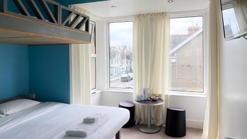 a bedroom with a bed and a large window at Reef Lodge in Newquay