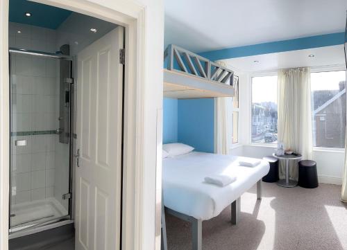 a bedroom with a bed and a bathroom with a shower at Reef Lodge in Newquay