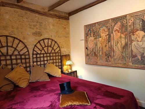 a bedroom with a purple bed with a painting on the wall at Au Pied du CHÂTEAU - 5 à 11 personnes - Baignade-canoë-piste cyclable à 100 m in Castelnaud La Chapelle