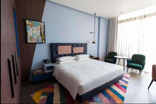 um quarto com uma cama grande, uma mesa e cadeiras em Hyatt Centric Jumeirah Dubai - King Room - UAE em Dubai