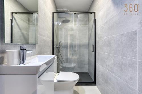 a bathroom with a shower and a toilet and a sink at The ultimate luxury triplex home in Spinola Bay by 360 Estates in St Julian's