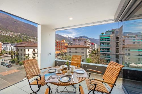 a dining room with a table and chairs on a balcony at Appartamento Lago e Monti - Happy Rentals in Locarno