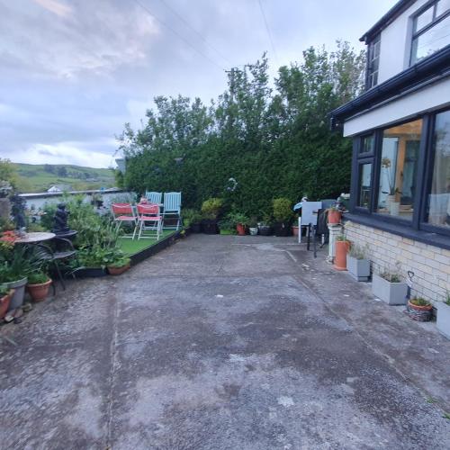 a patio of a house with chairs and plants at St Martins Old Schoolhouse Ballyroe Tralee in Tralee