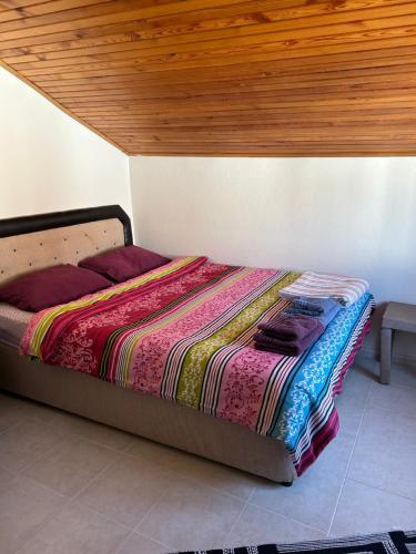 een bed in een slaapkamer met een houten plafond bij Denize 200 metre, 3+1 Bahçeli Villa in Ortaköy