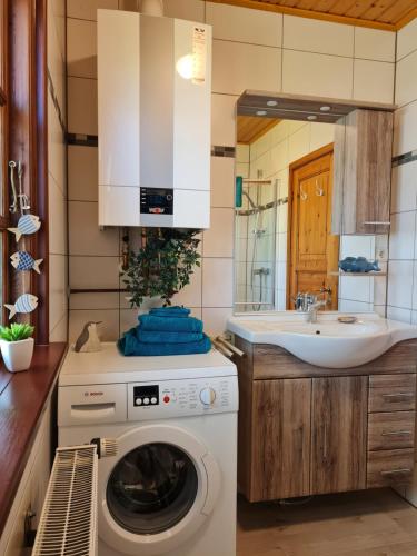 a kitchen with a washing machine and a sink at Ferienhaus Weitblick in Busenwurth
