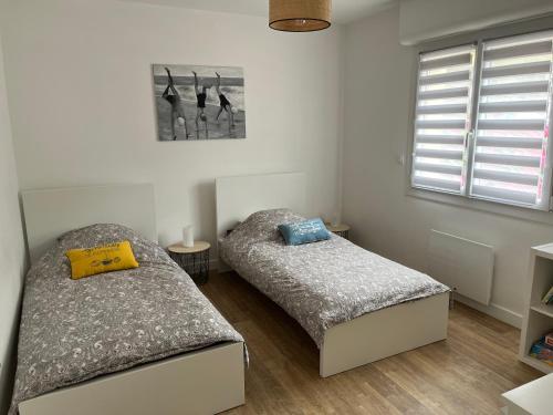 une chambre avec deux lits et une fenêtre dans l'établissement Ty-magritt, à Saint-Nic