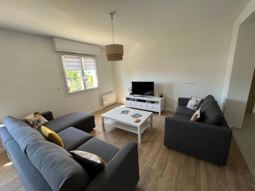 un salon avec deux canapés et une télévision dans l'établissement Ty-magritt, à Saint-Nic