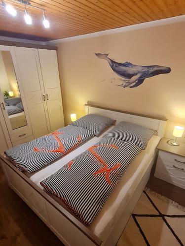 a bedroom with a bed with a dolphin on the wall at Ferienhaus Weitblick in Busenwurth
