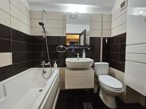 a bathroom with a sink and a toilet and a bath tub at Victoria Residence Iași Aeroport in Iaşi