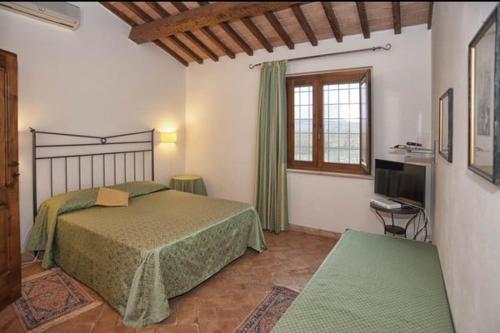 ピティリアーノにあるAgriturismo Poggio delle Concheのベッドルーム(大型ベッド1台、窓付)