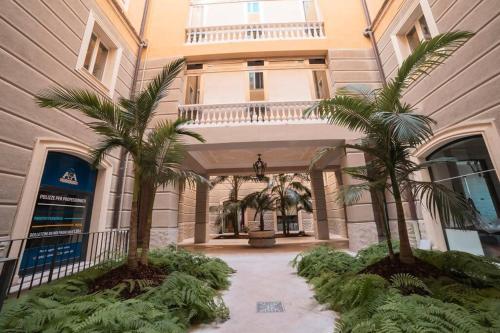 a building with two palm trees in front of it at Davids Room Palazzo Tamborino in Lecce