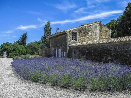 a field of lavender in front of an old stone building at La Moutière in Colonzelle