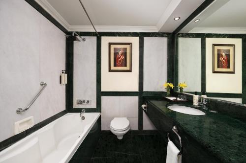 een badkamer met een bad, een toilet en een wastafel bij V Sarovar Portico MI Road Jaipur in Jaipur